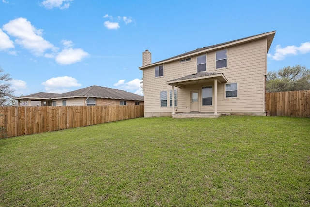 back of property with a patio, a lawn, a fenced backyard, and a chimney