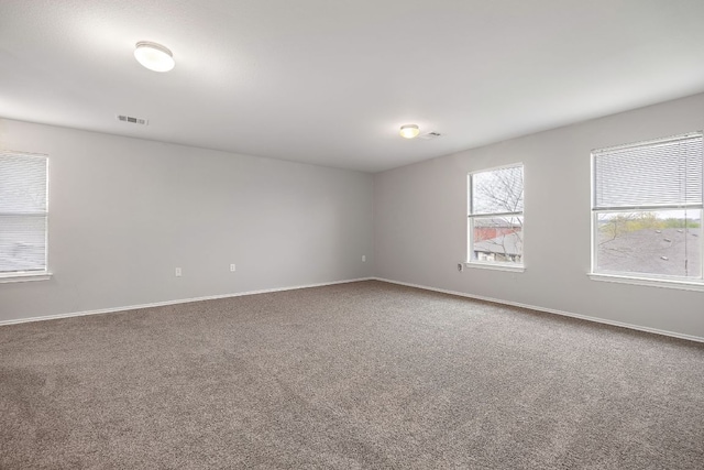 carpeted empty room with visible vents and baseboards