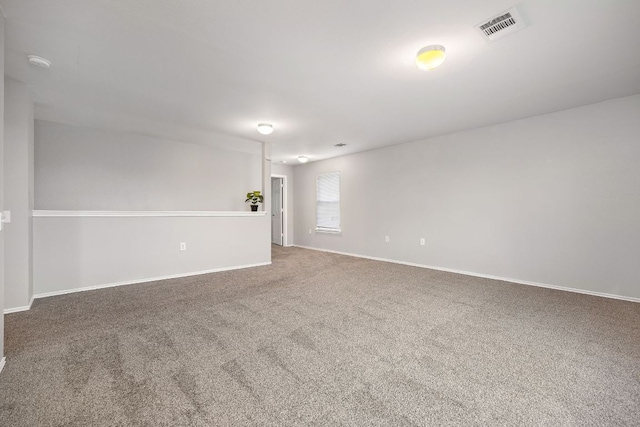 unfurnished room with visible vents, baseboards, and carpet