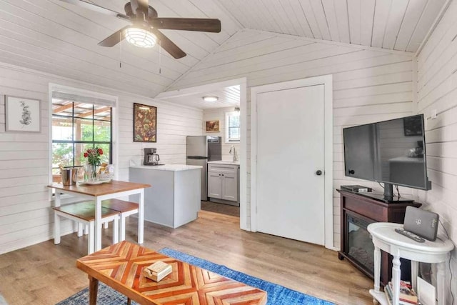 living room with plenty of natural light, lofted ceiling, and light wood finished floors