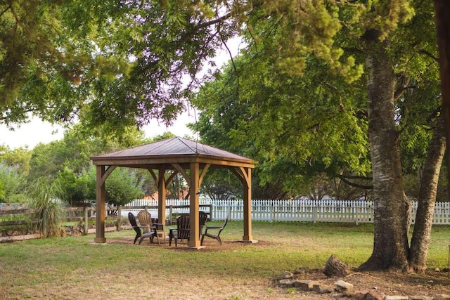 view of home's community with a gazebo, a lawn, and fence