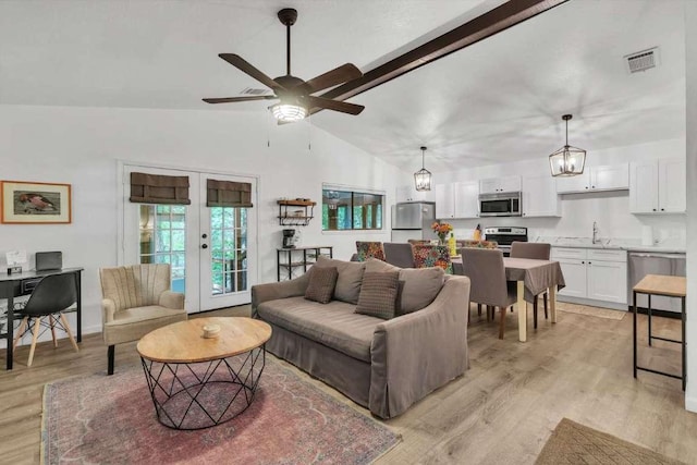 living room with a ceiling fan, visible vents, light wood-style flooring, vaulted ceiling, and french doors