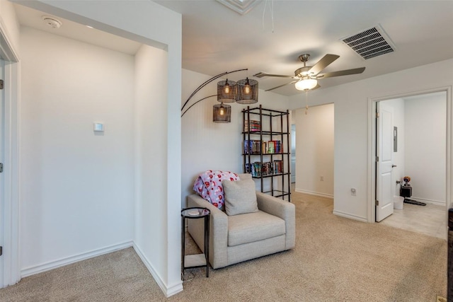 sitting room featuring a ceiling fan, carpet, visible vents, baseboards, and attic access