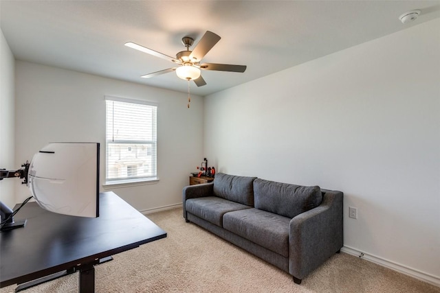 home office featuring light colored carpet, baseboards, and ceiling fan