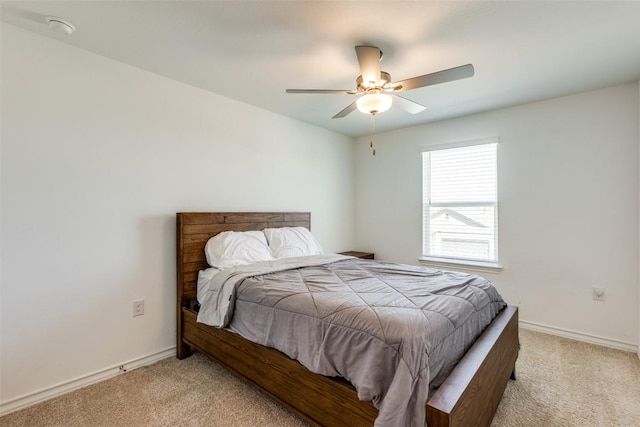 bedroom with light colored carpet, baseboards, and ceiling fan