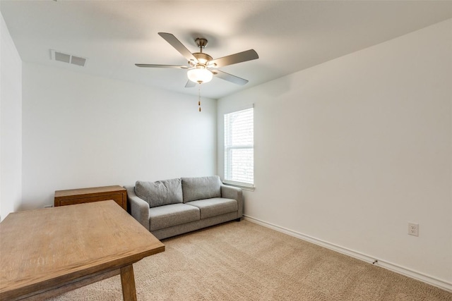 living room with visible vents, baseboards, light colored carpet, and a ceiling fan