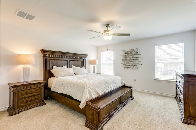 bedroom featuring multiple windows, baseboards, visible vents, and light carpet