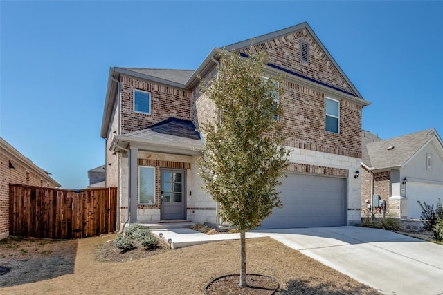 view of front of house with brick siding, driveway, an attached garage, and fence