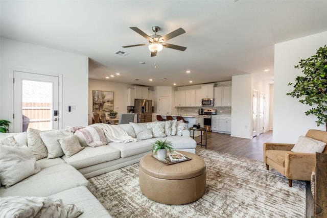 living area featuring recessed lighting, visible vents, wood finished floors, and a ceiling fan