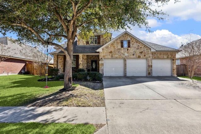 traditional-style home with a front lawn, stone siding, concrete driveway, an attached garage, and fence
