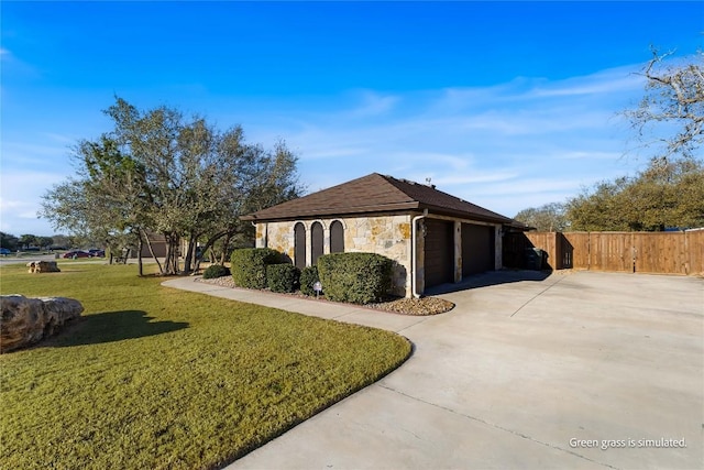 view of side of property featuring fence, a lawn, a garage, stone siding, and driveway