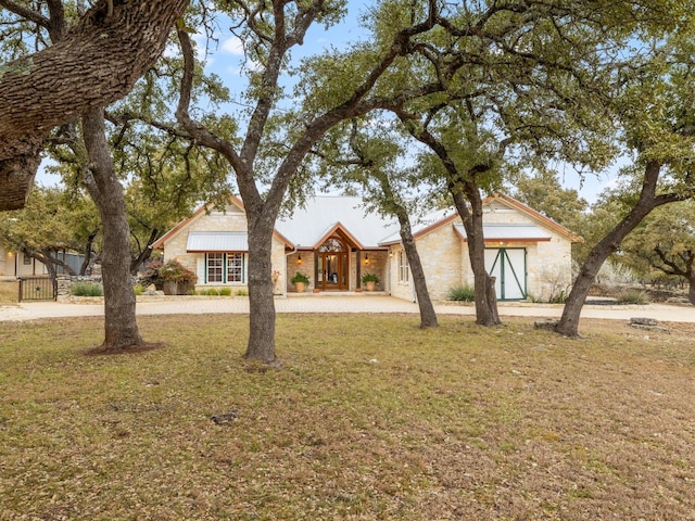 view of front of home featuring stone siding and a front lawn