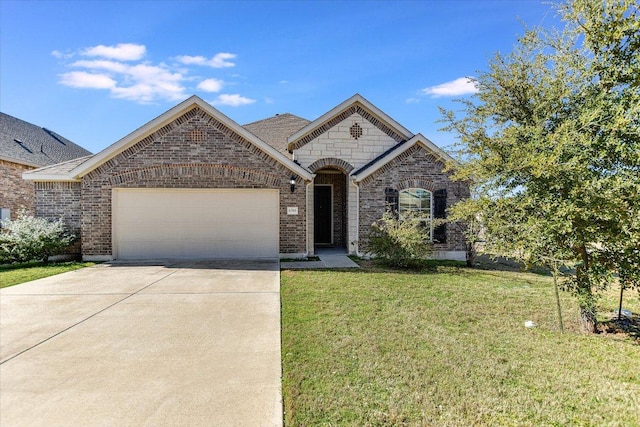 french country style house with brick siding, driveway, a front lawn, and an attached garage