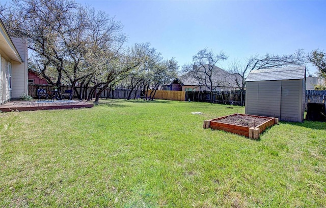 view of yard with a vegetable garden, a fenced backyard, an outdoor structure, a storage unit, and a patio area