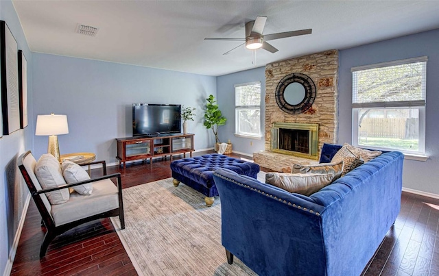 living area with a fireplace, visible vents, dark wood-style flooring, and baseboards