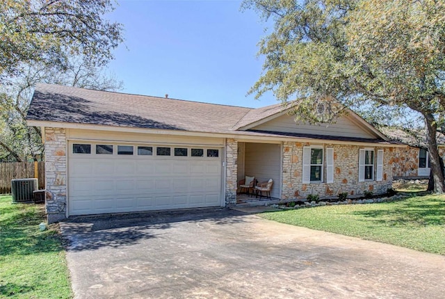 single story home featuring driveway, stone siding, fence, a front yard, and a garage