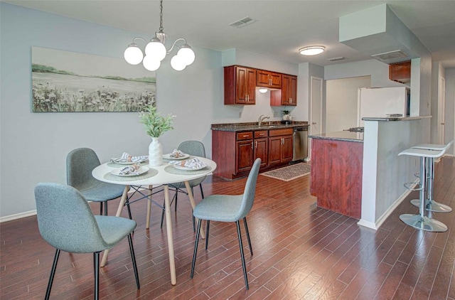 dining space featuring visible vents, baseboards, a notable chandelier, and dark wood finished floors