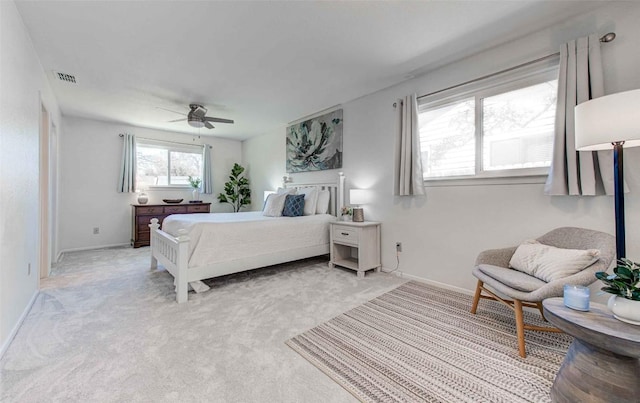 bedroom featuring light carpet, visible vents, baseboards, and ceiling fan