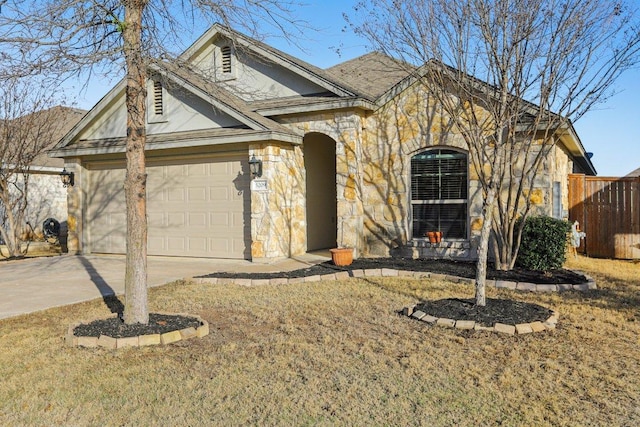 view of front of property with an attached garage, stone siding, and driveway