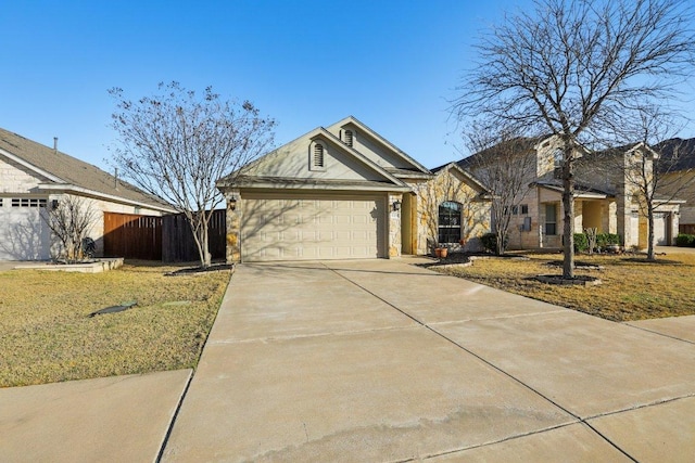 view of front of home featuring an attached garage, driveway, and fence