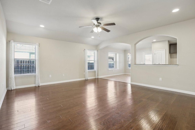 unfurnished living room featuring a wealth of natural light, baseboards, and wood finished floors