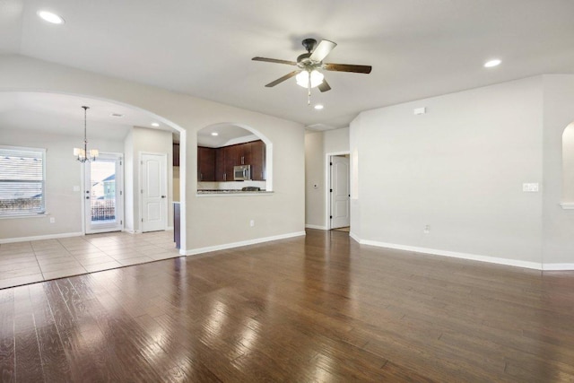 unfurnished living room with recessed lighting, baseboards, wood finished floors, and ceiling fan with notable chandelier