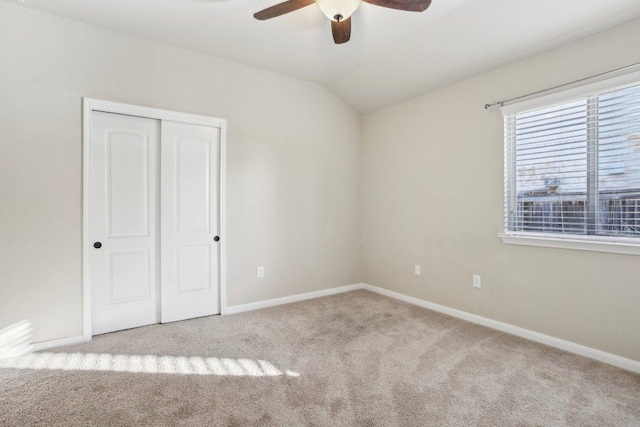 unfurnished bedroom featuring a closet, carpet floors, baseboards, and vaulted ceiling