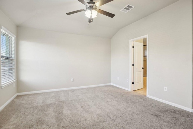 spare room featuring visible vents, plenty of natural light, light colored carpet, and baseboards