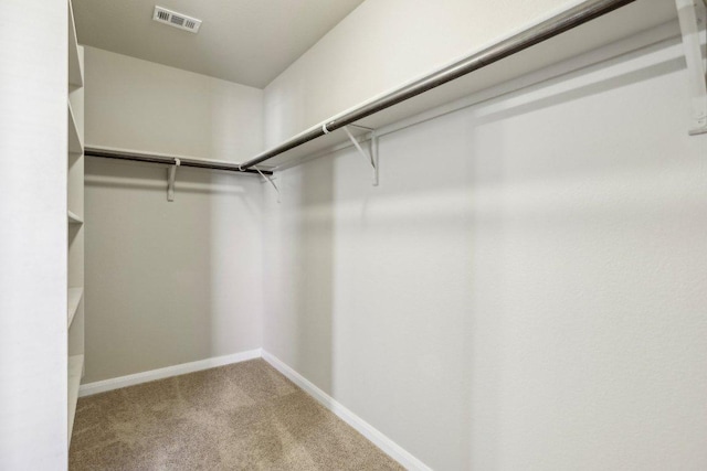 walk in closet with visible vents and carpet