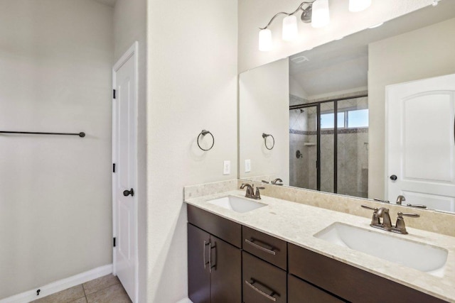 full bathroom featuring a sink, baseboards, a stall shower, and tile patterned flooring