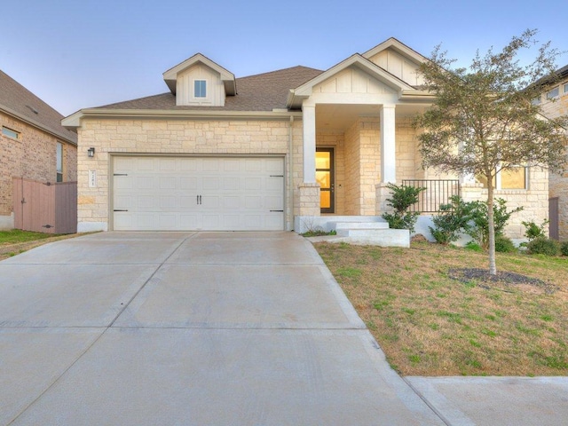 view of front of home featuring stone siding, concrete driveway, a garage, and a shingled roof