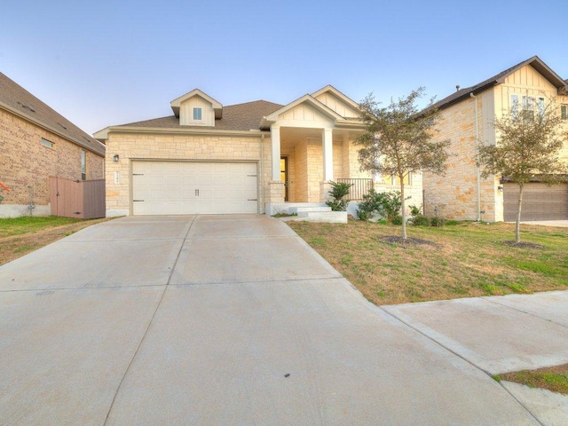 view of front of home with a porch, concrete driveway, a front yard, a garage, and stone siding