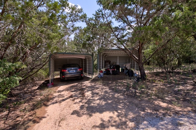 exterior space featuring a carport and dirt driveway