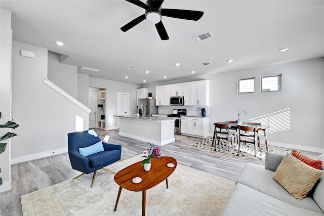 living area with visible vents, recessed lighting, light wood finished floors, baseboards, and ceiling fan