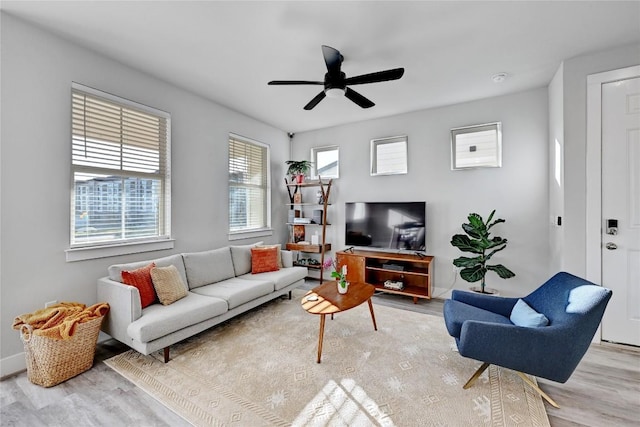 living area with ceiling fan, baseboards, and wood finished floors