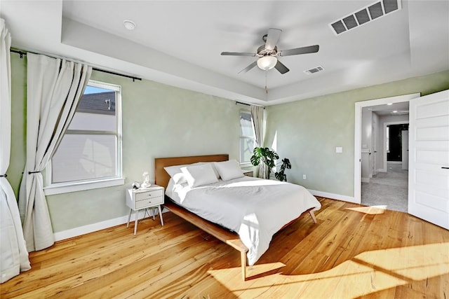 bedroom featuring visible vents, baseboards, and wood finished floors