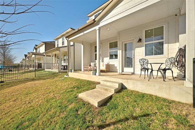 view of yard featuring a residential view, covered porch, and fence