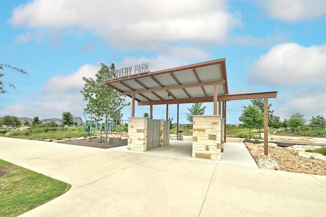 surrounding community with concrete driveway and a carport