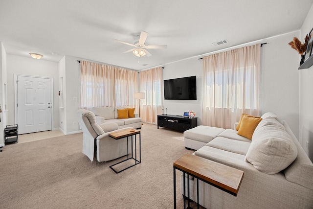 living room featuring carpet flooring, baseboards, visible vents, and ceiling fan