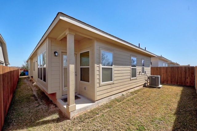 view of property exterior featuring cooling unit, a lawn, and a fenced backyard