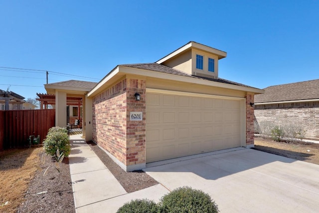 view of front of property with brick siding, an attached garage, driveway, and fence