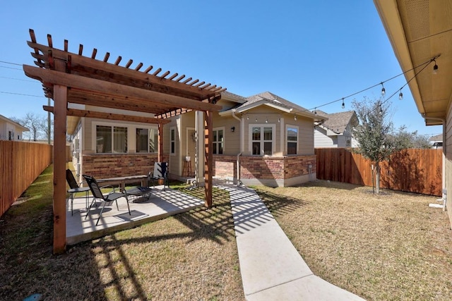 back of property with a pergola, a fenced backyard, a yard, brick siding, and a patio area