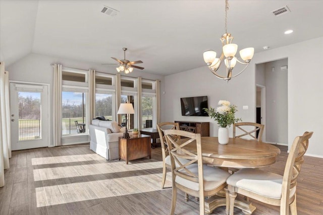 dining area with light wood-type flooring, visible vents, ceiling fan with notable chandelier, recessed lighting, and lofted ceiling