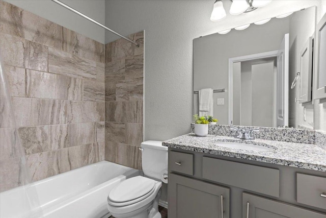 full bathroom with vanity, toilet, tub / shower combination, and a textured wall