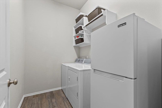 washroom featuring baseboards, dark wood-type flooring, washing machine and dryer, and laundry area