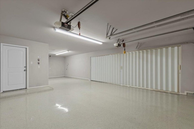 garage featuring a garage door opener and baseboards