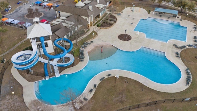 community pool with a patio, a water slide, and a water play area