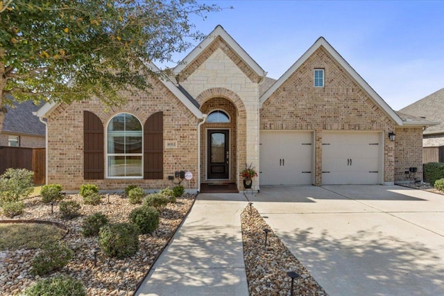 view of front of property featuring an attached garage, brick siding, and driveway