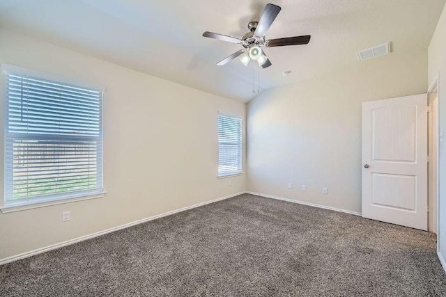 carpeted spare room featuring visible vents, baseboards, a ceiling fan, and vaulted ceiling