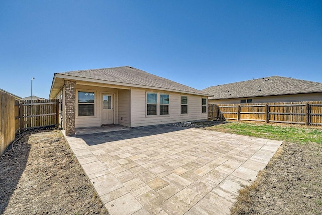 rear view of house with a patio and a fenced backyard